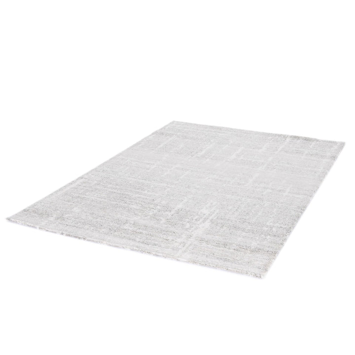 Angled view of a large grey rug on white background.