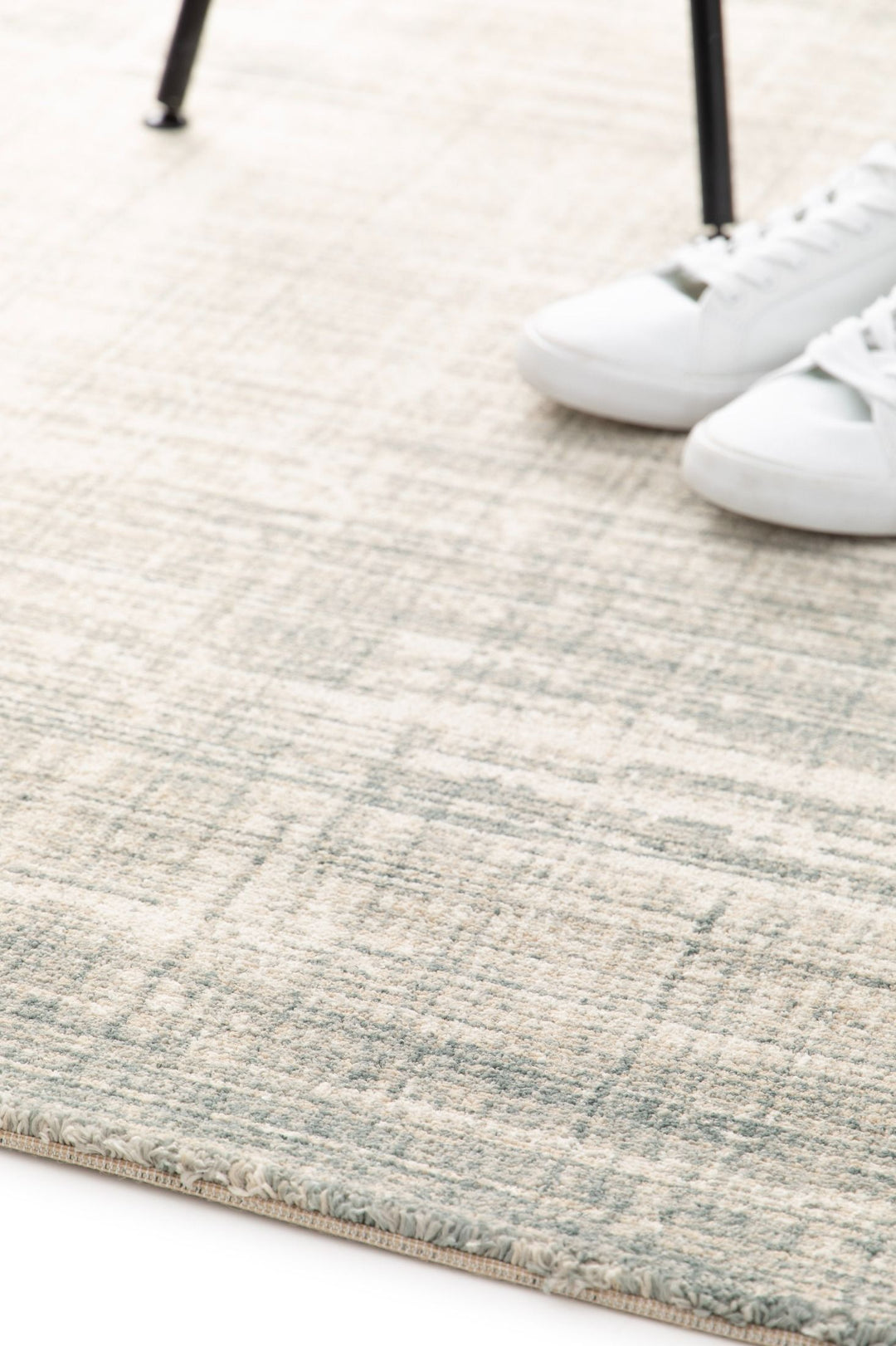 Rug corner with shoes on top showing its thickness.