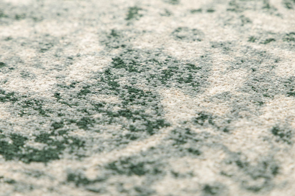 Texture detail of a light grey and beige rug surface.