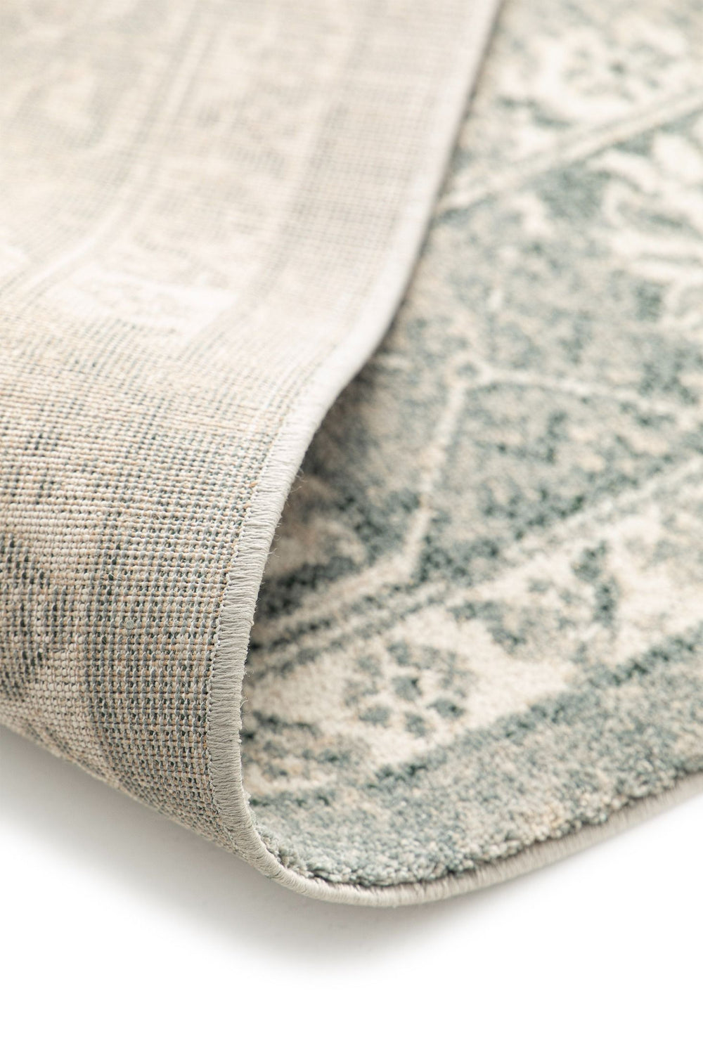 Folded rug corner showing backing and texture.