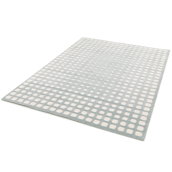 Light blue rug with white square pattern.