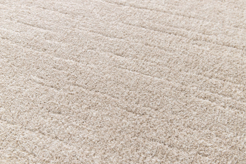 Close-up shot of beige rug’s plush surface.