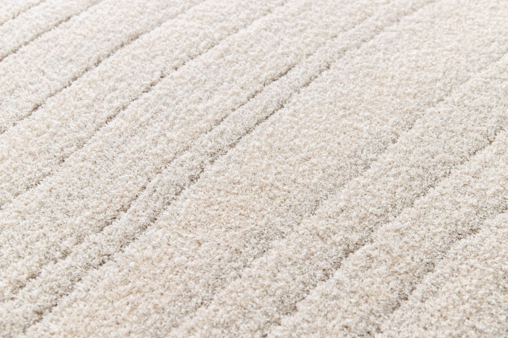 Close-up of soft cream rug surface showing plush lines.