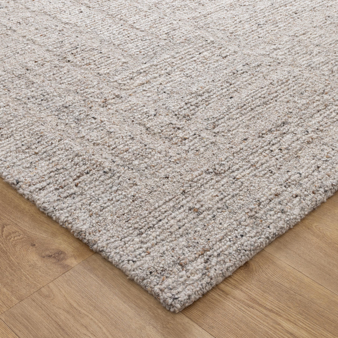 Beige wool loop rug on a wooden floor