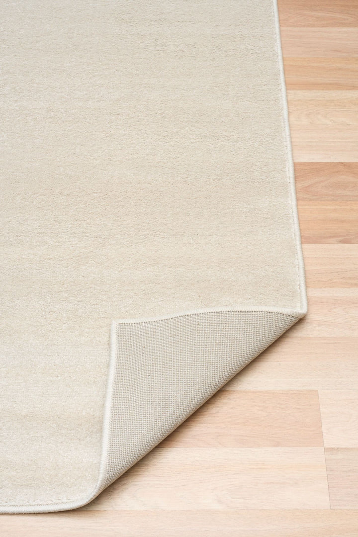 Cyrus rug with folded edge on wood floor.