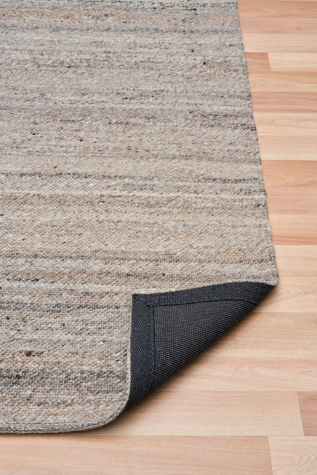 Close-up of rug corner folded to show woven backing detail.