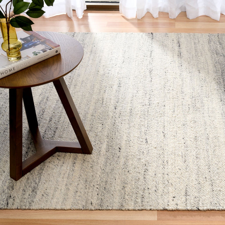 Square view of silver rug in a room with neutral furniture.