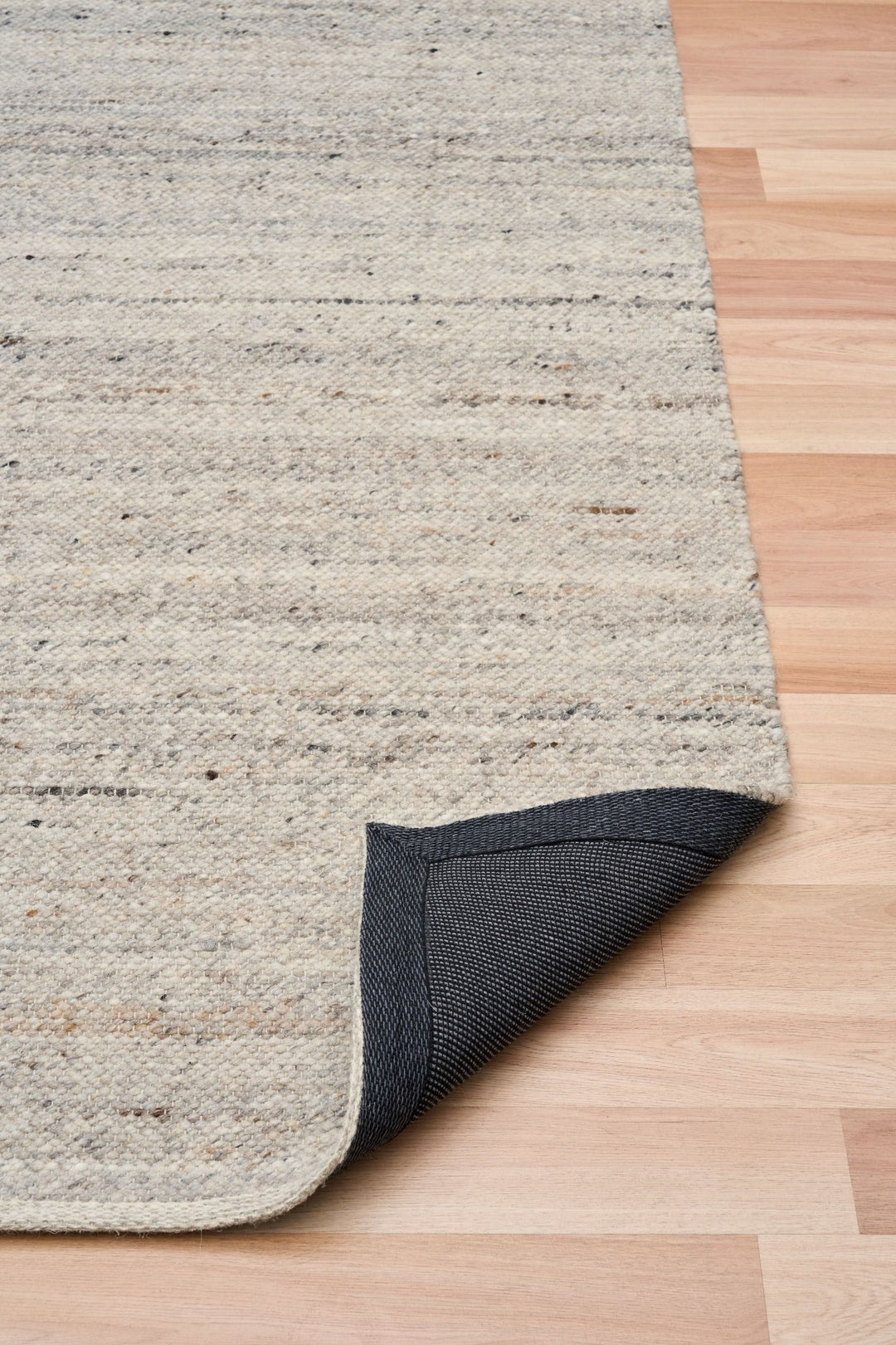 The Harmony Smoke Grey rug corner folded to show backing detail.