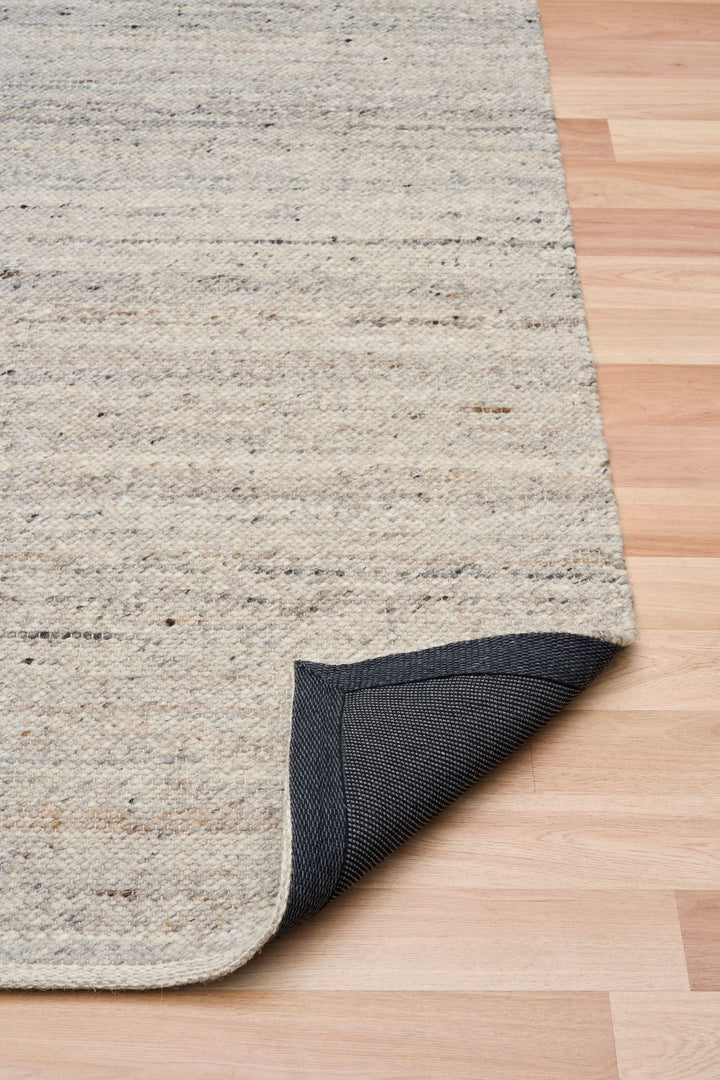 The Harmony Smoke Grey rug corner folded to show backing detail.
