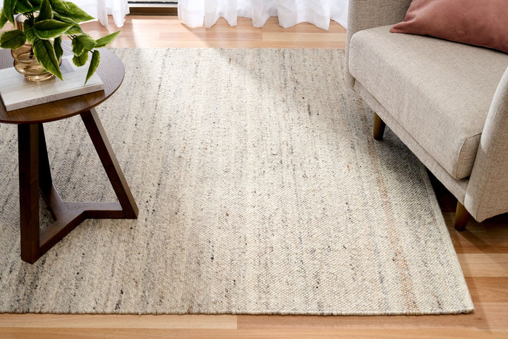 The Harmony Smoke Grey rug styled in a modern living room with sofa and table.