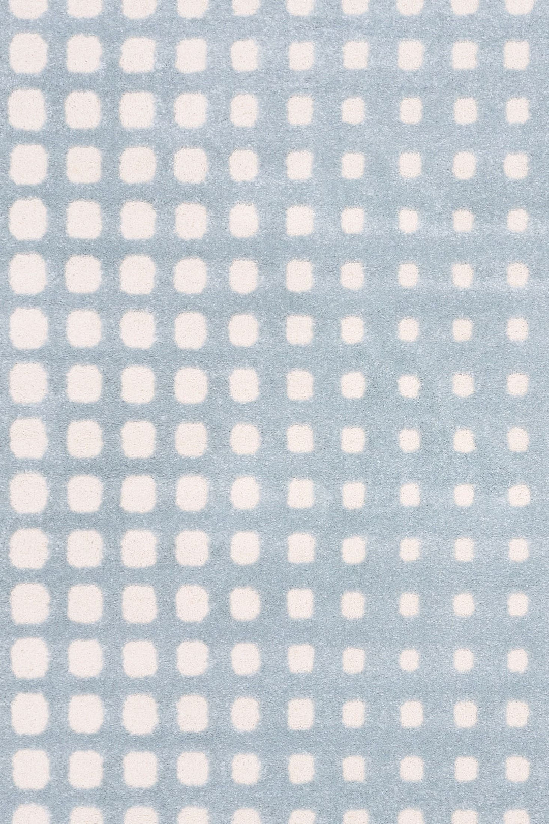 Close-up of blue rug with soft white square pattern.