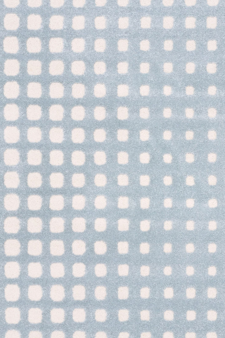 Close-up of blue rug with soft white square pattern.