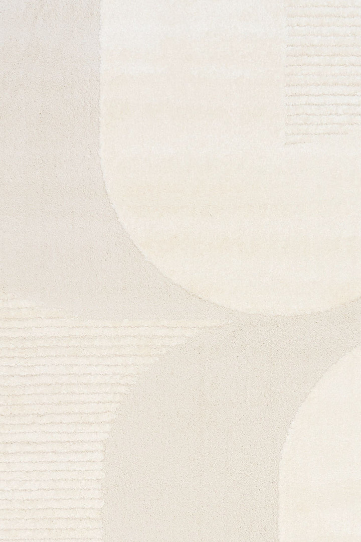 Close-up of cream rug showing curved abstract pattern.