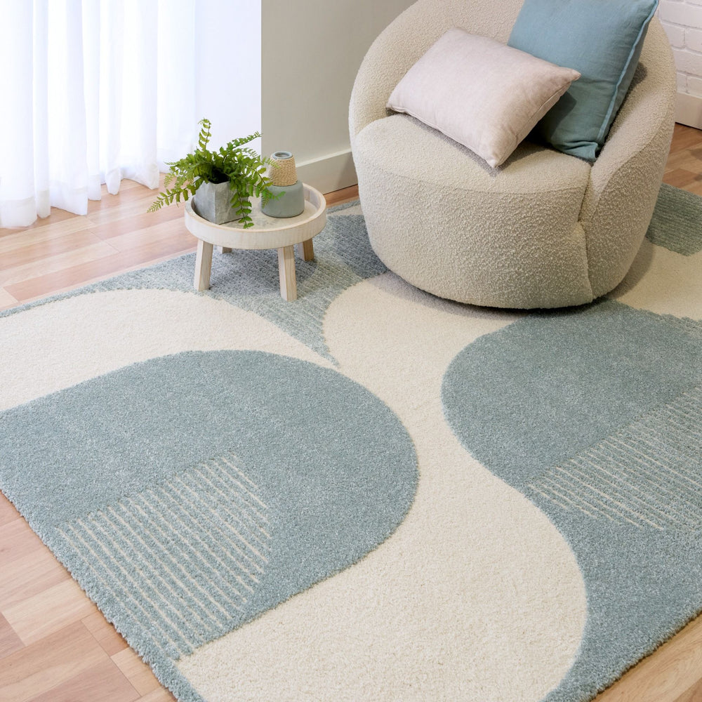 Rug styled in living room with chair and cushion.