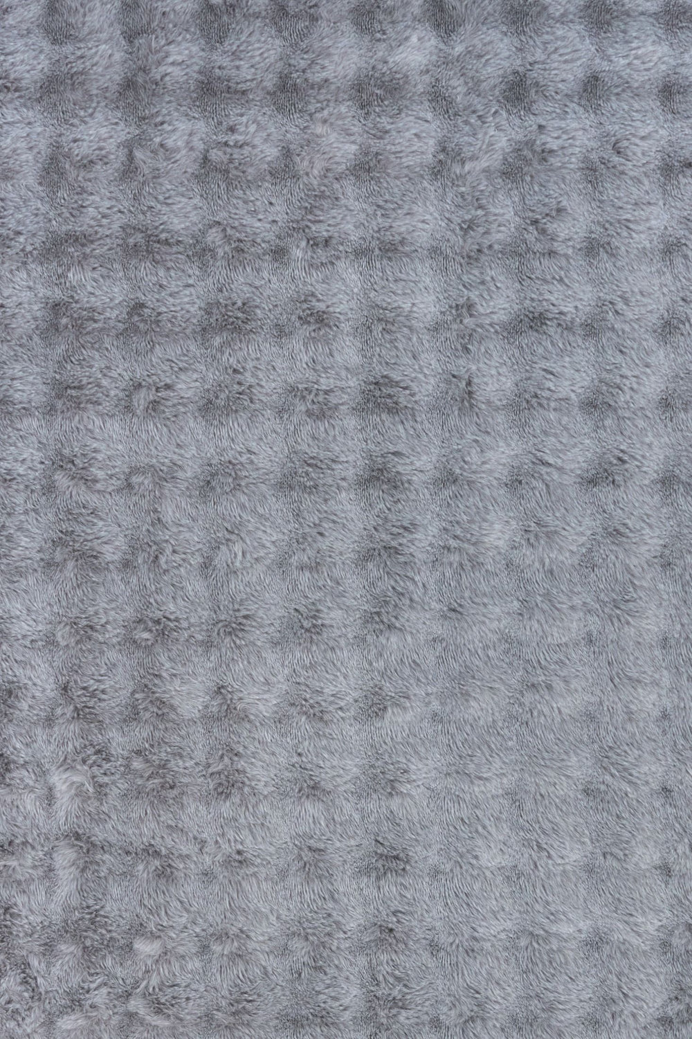 Close-up of grey textured fluffy rug fabric.