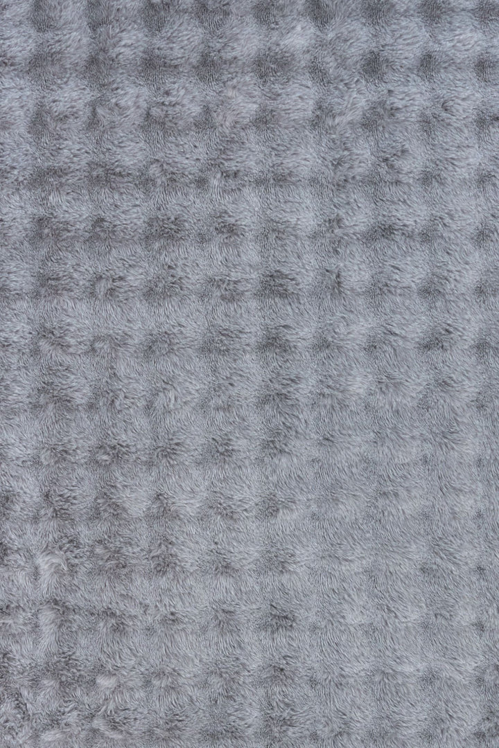 Close-up of grey textured fluffy rug fabric.