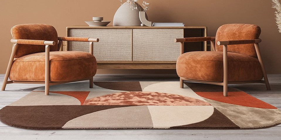 luxurious blend of wool and viscose in bold, hand-carved geometric patterns. Showcased in a modern living room with tan armchairs and terracotta accents, this contemporary rug