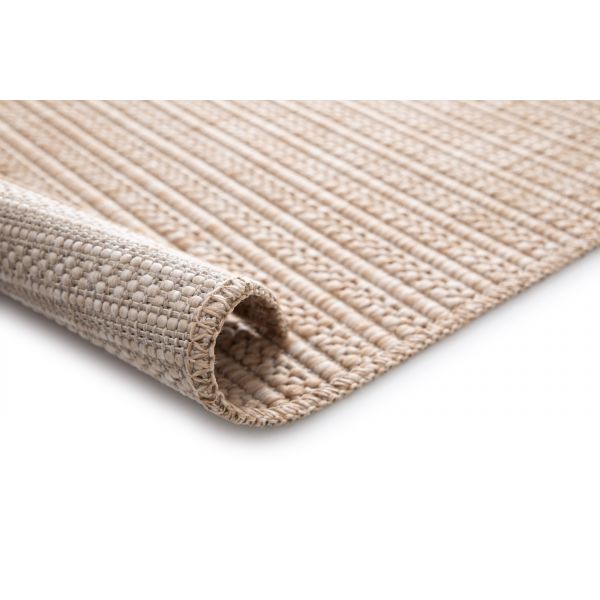 Beige woven rug with raised diamond lattice, rolled corner, stitched edge, and backing on white.