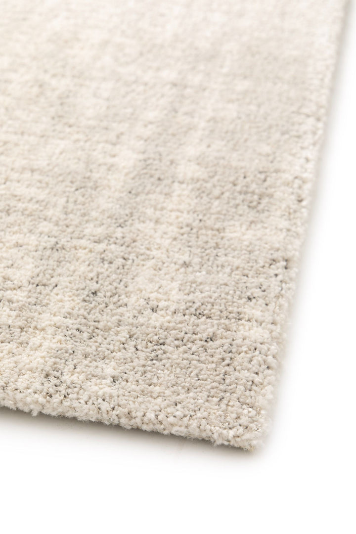 Close-up of a beige rug surface with soft texture.