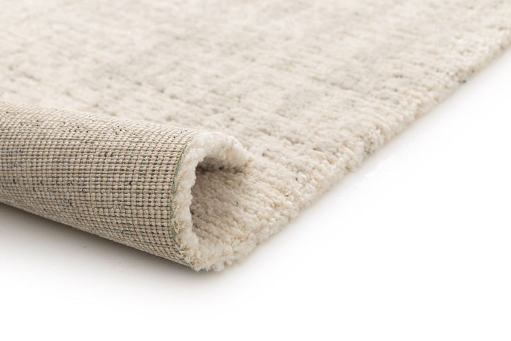 Close-up of a rolled beige textured rug.