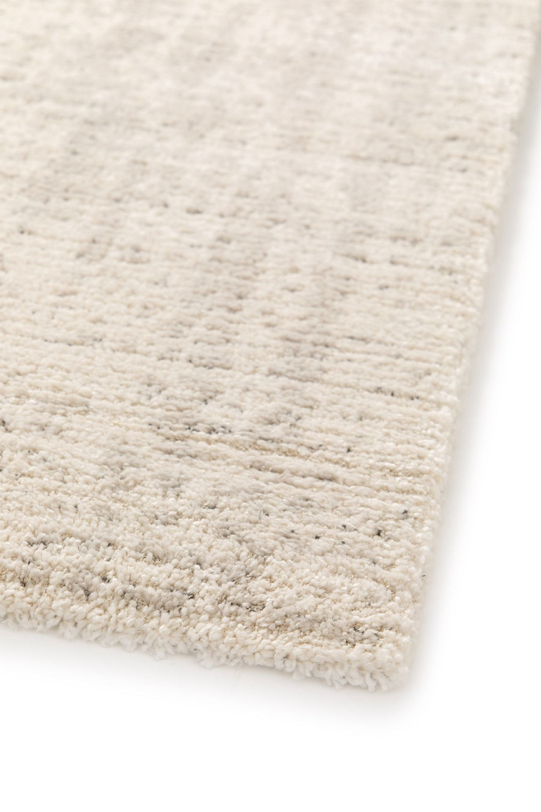 Corner view of a soft beige rug.