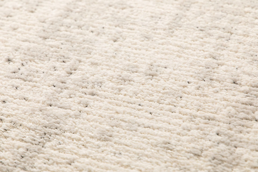 Macro shot showing plush beige rug texture.