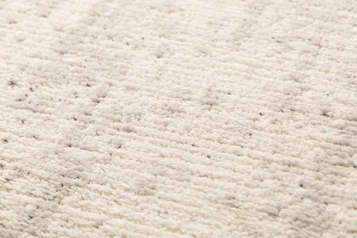 Macro shot showing plush beige rug texture.