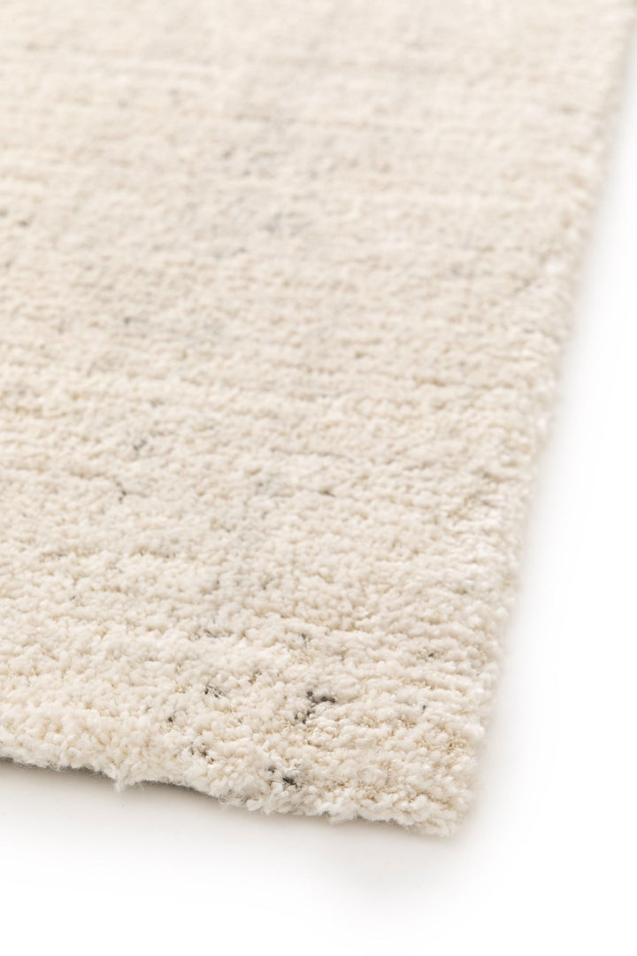 Close-up beige rug corner view.