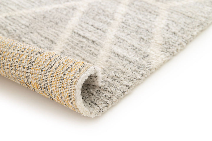 Rolled edge of a grey patterned rug.