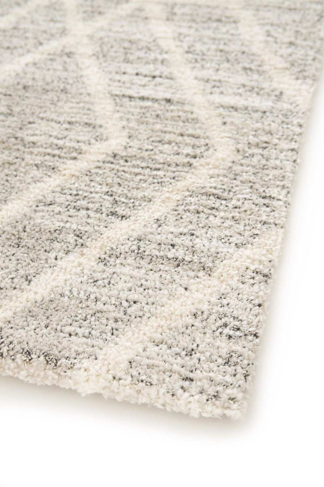 Close-up corner of a grey geometric rug.