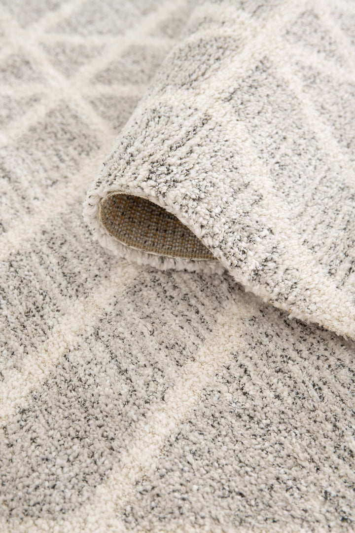 Folded edge showing thickness of a grey rug.