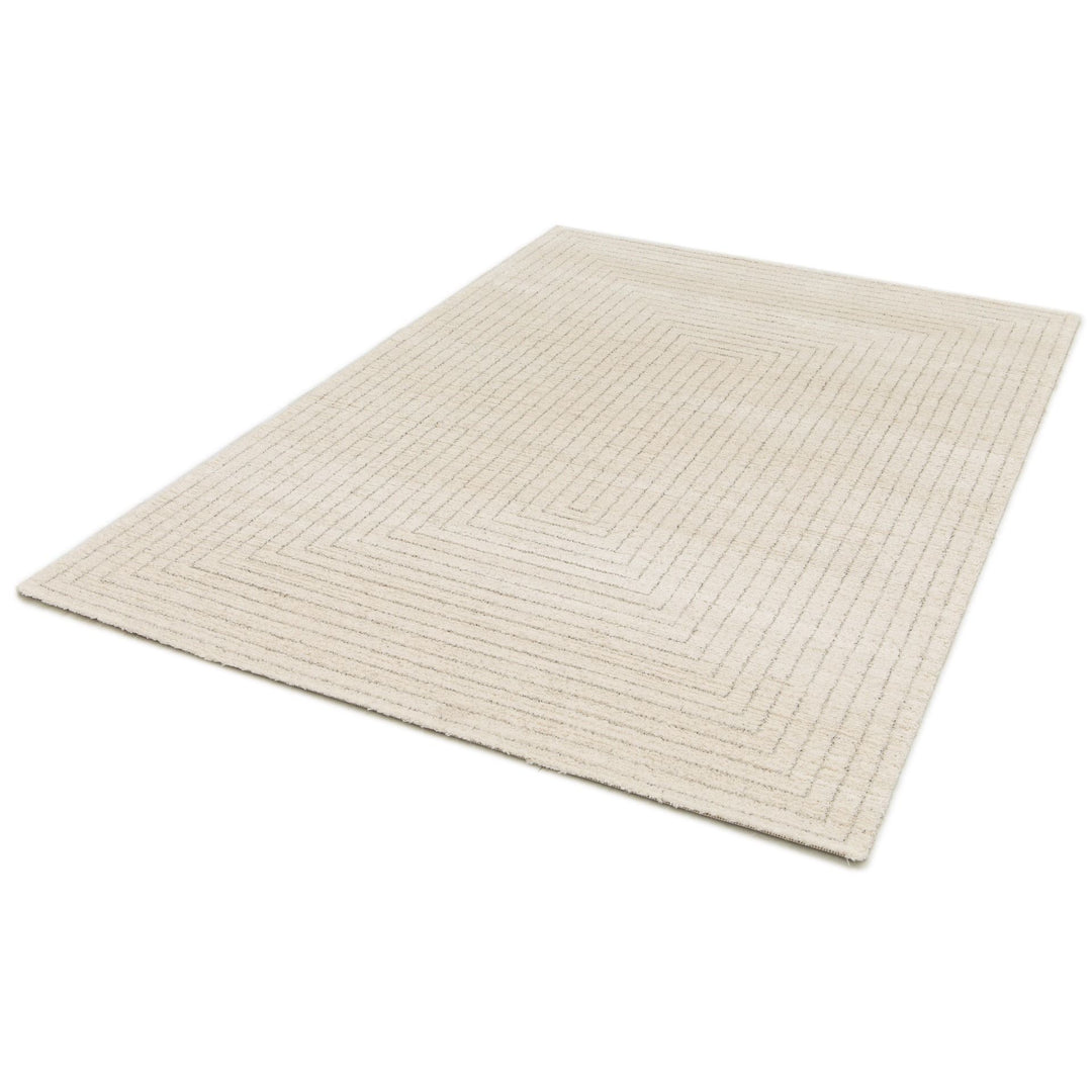 An angled view of a cream rug with a subtle geometric border pattern.