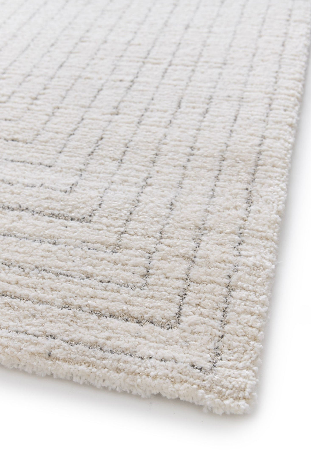 Side angle of a cream rug showing textured linear details.