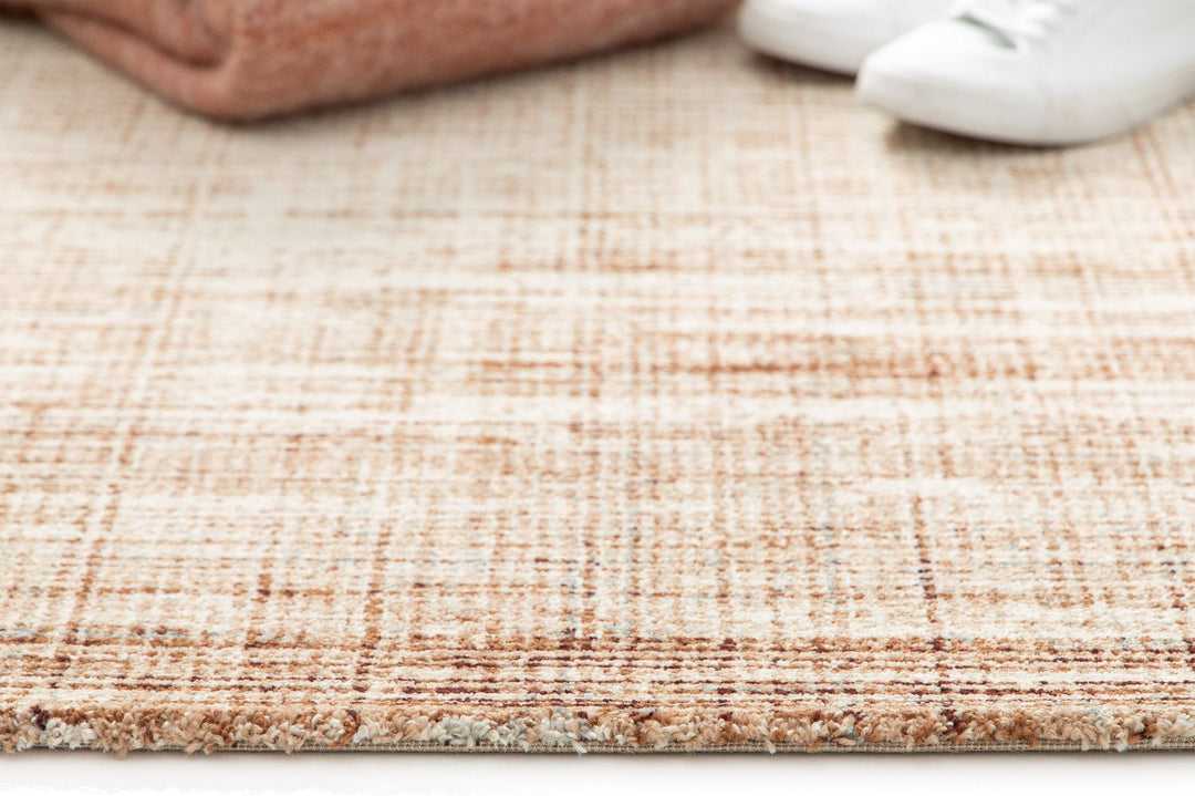 A brown and cream textured rug with a woven pattern.