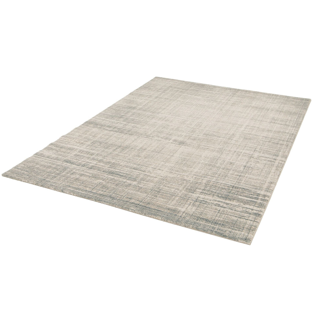 Angled view of rectangular rug with abstract design.