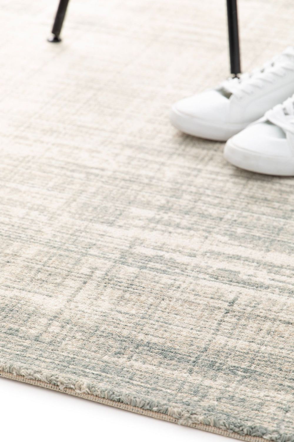 Rug corner with shoes on top showing its thickness.