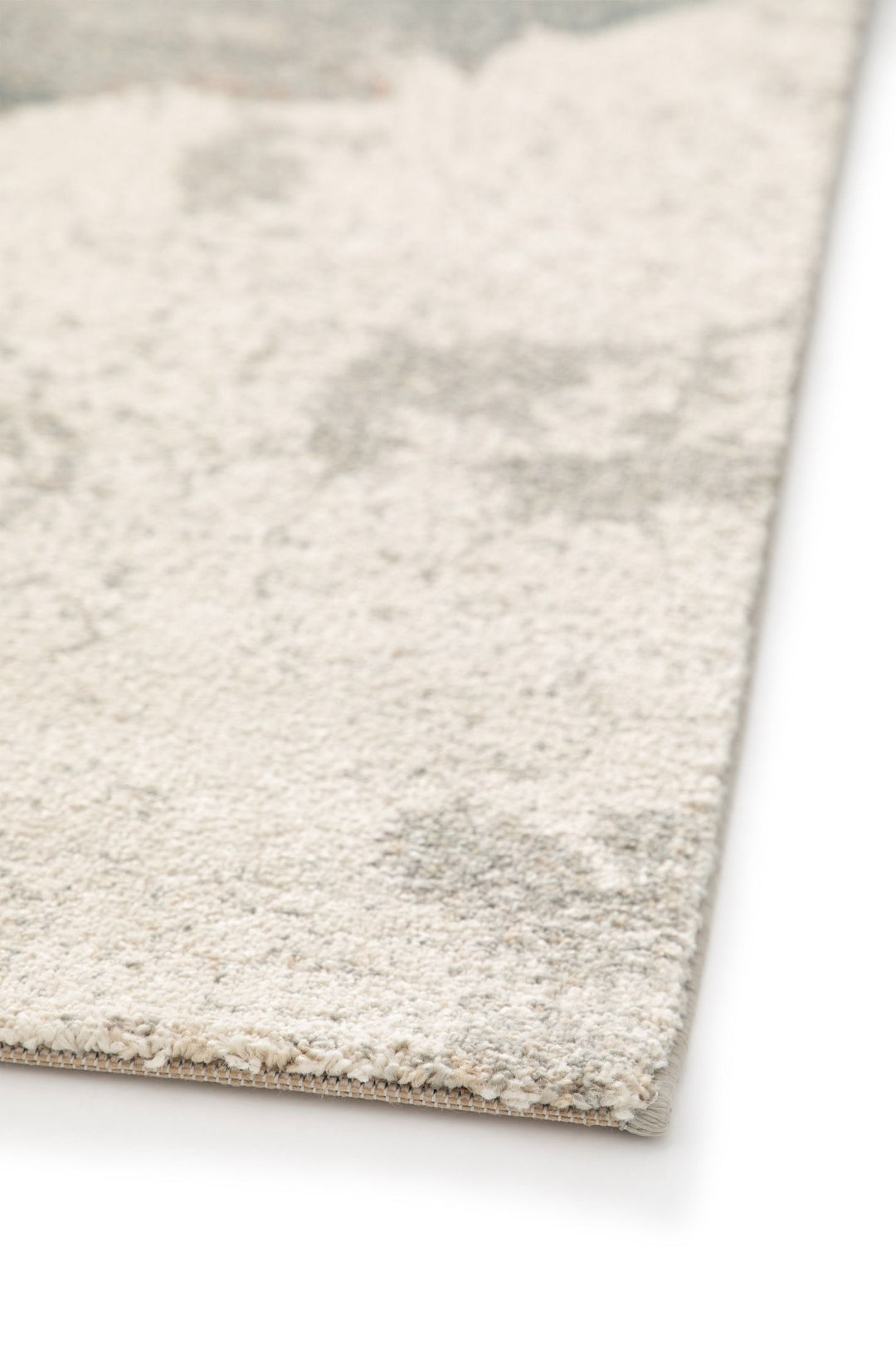 A close-up view of a rug edge with a soft pile texture.