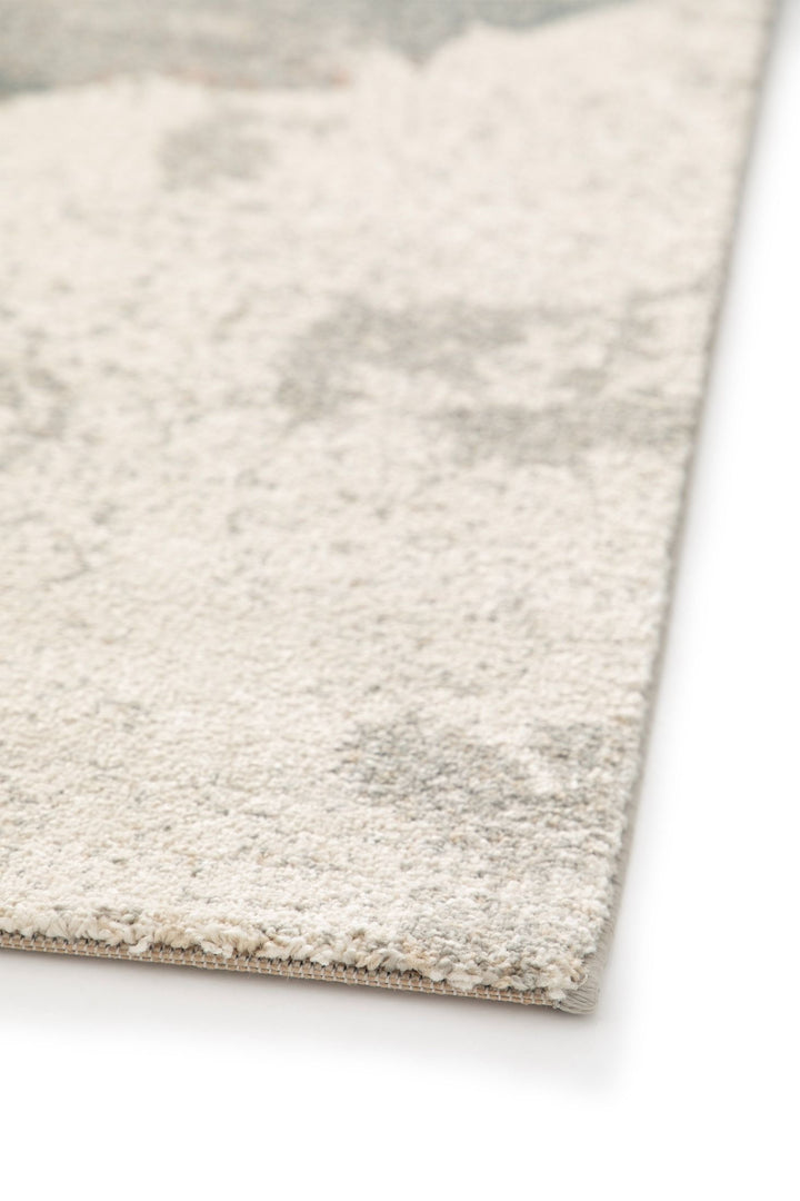 A close-up view of a rug edge with a soft pile texture.