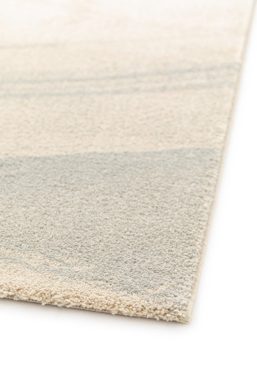 Close-up of rug edge with beige and gray texture.