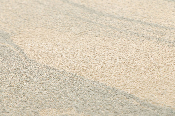 Soft textured surface of beige and gray rug.