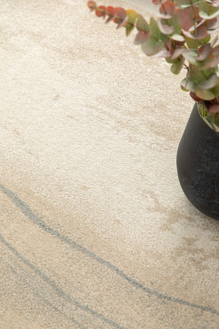 Rug corner with vase and green leaves on top.