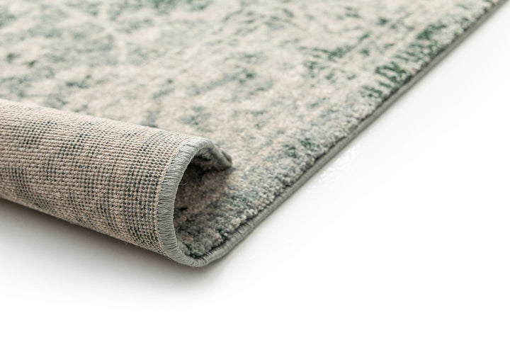 Close-up of a rug corner rolled to show the underside.