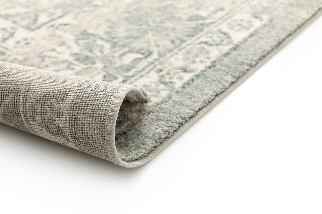 Close-up of a rolled corner of a patterned rug.