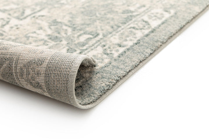 Close-up of a rolled corner of a patterned rug.