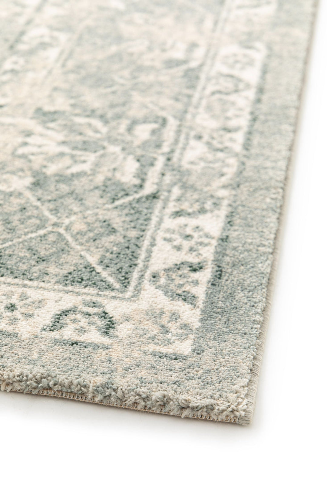 Edge detail of a grey and cream rug.