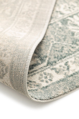 Folded rug corner showing backing and texture.