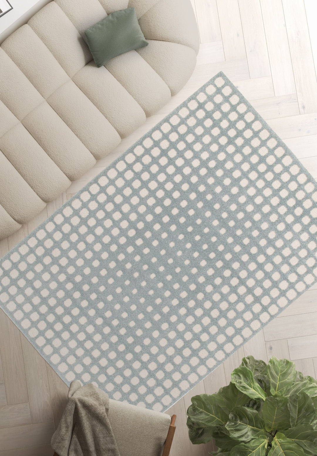 Blue and white patterned rug under sofa and cushion.