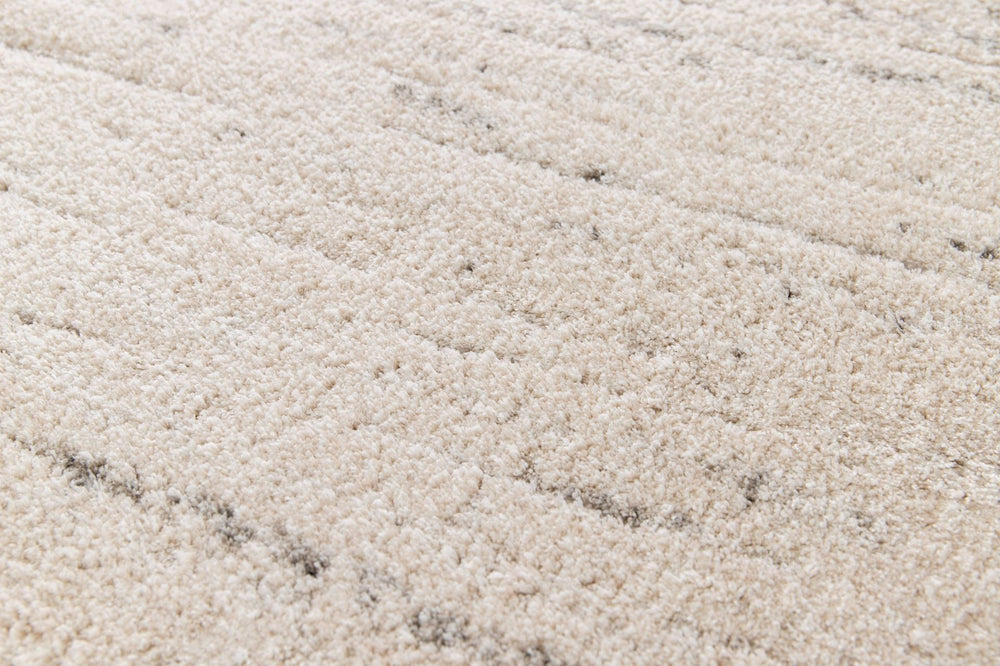 Close-up of plush cream rug with soft grey lines.