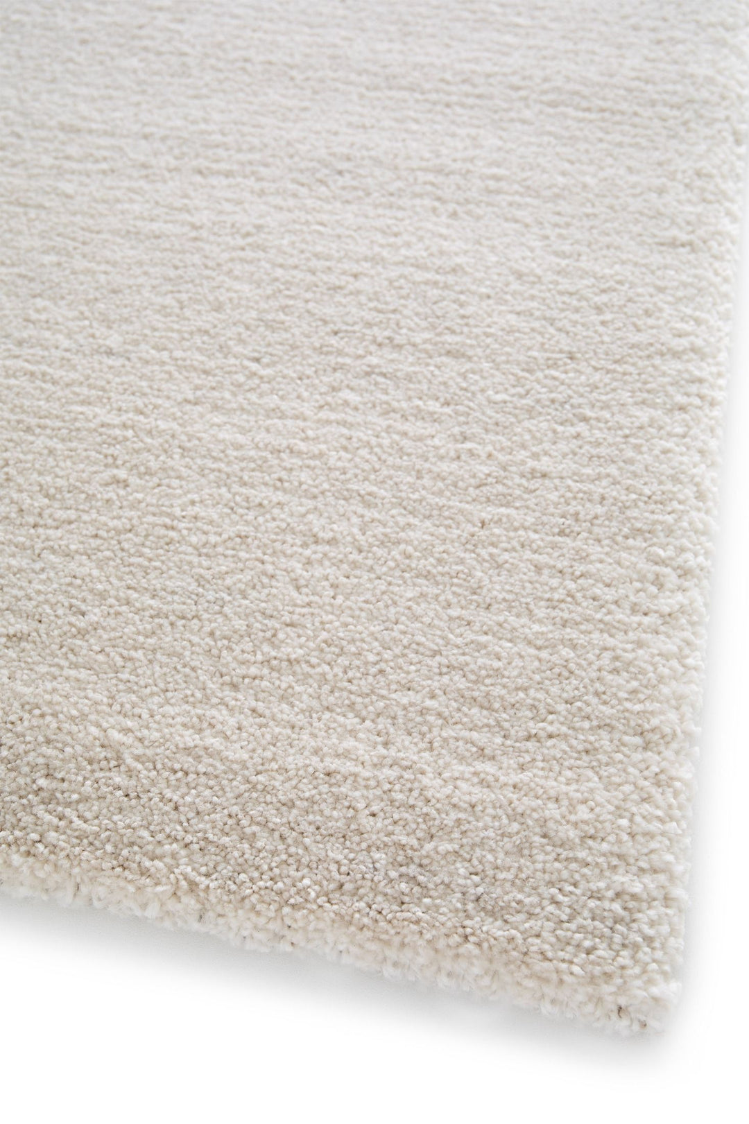 Close-up of beige rug corner showing surface texture.