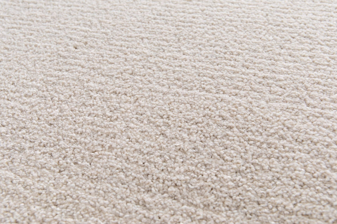 Close-up showing the soft pile texture of a beige rug.